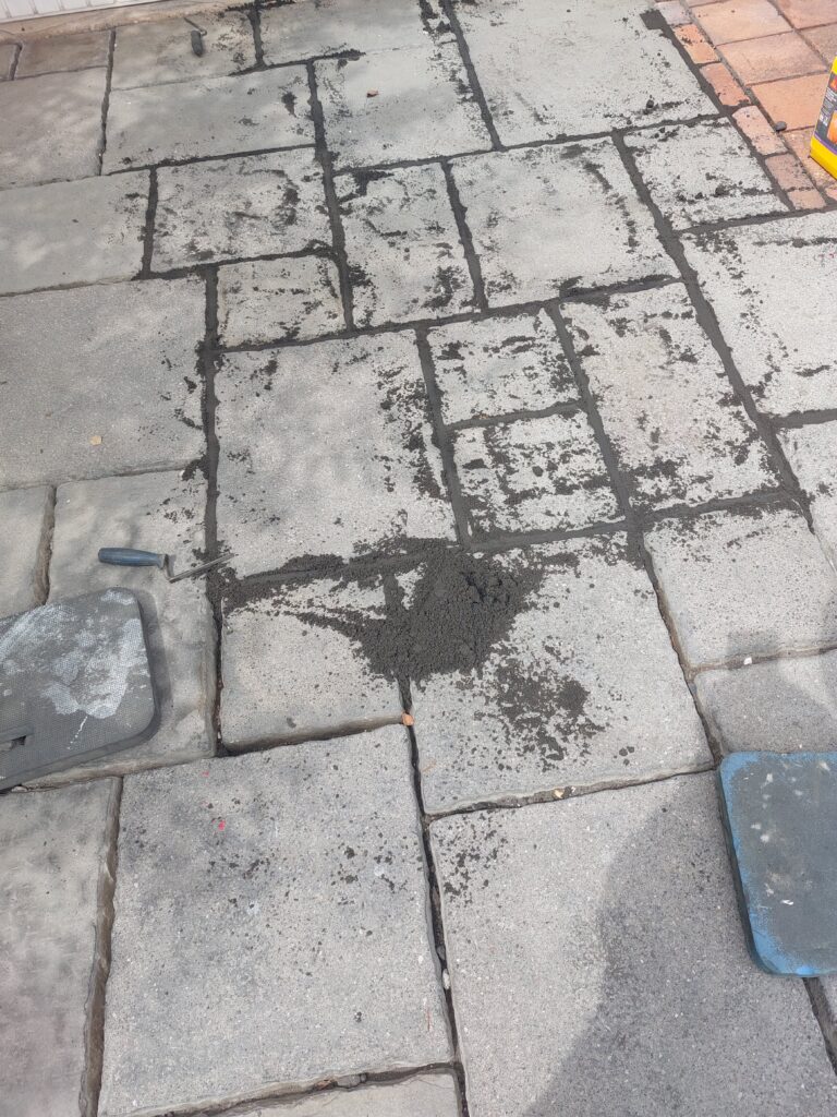 sand cement mortar being pressed into patio joints